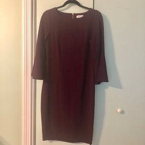 Dark plum sheath dress with bell sleeves.